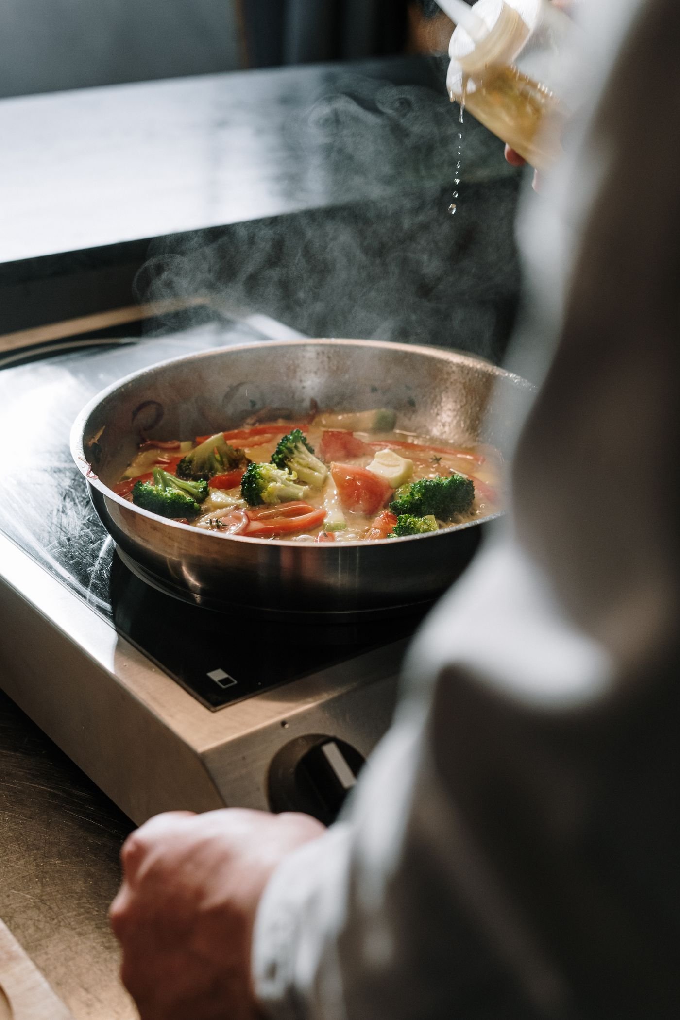 Vegetables sizzling in a stainless skillet